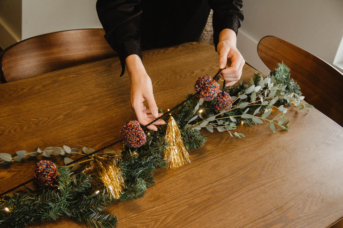 gumball tassel garland being placed on holiday garland